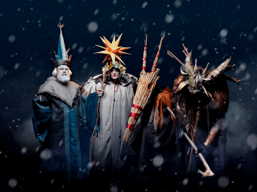 Fire udklædte julevæsner udenfor i sneen